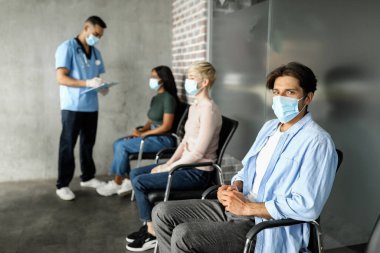 Klinikte koronavirüse karşı aşı bekleyen çok ırklı hastalar