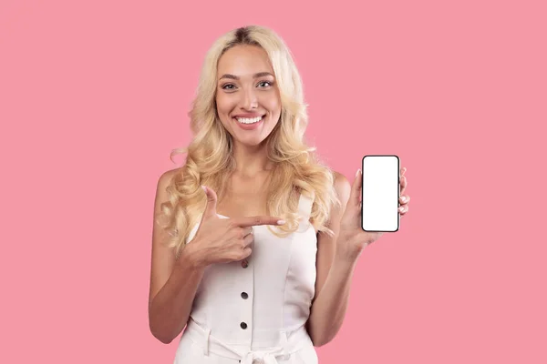 Beyaz, boş akıllı telefon ekranını tutan ve işaret eden kadın — Stok fotoğraf