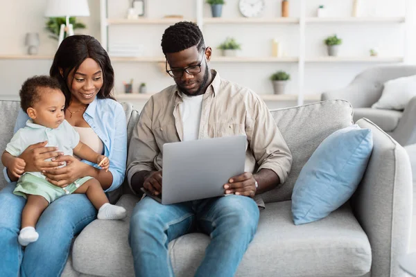 Afrikaans Amerikaans gezin met behulp van computer met baby thuis — Stockfoto