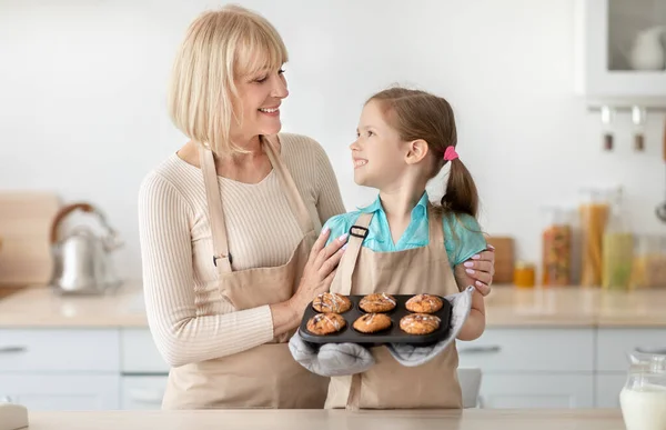 Boldog idős nő és unokája muffint készít — Stock Fotó