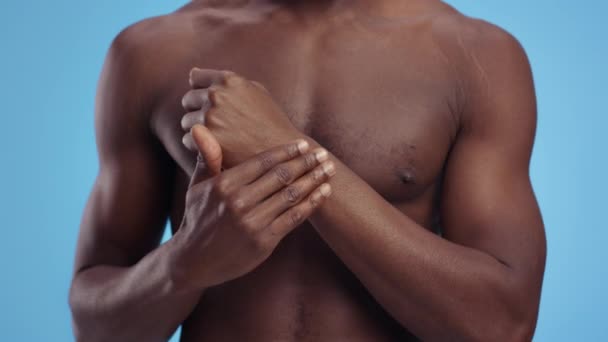 Gezondheidszorg en medische behandeling. Onherkenbare shirtloze gespierde man wrijft helende crème op zijn beschadigde pols — Stockvideo