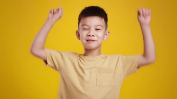 Hurá. Roztomilý malý asijský chlapec zvedá ruce a křičí, těší skvělé zprávy nebo překvapení, usmívá se do kamery — Stock video