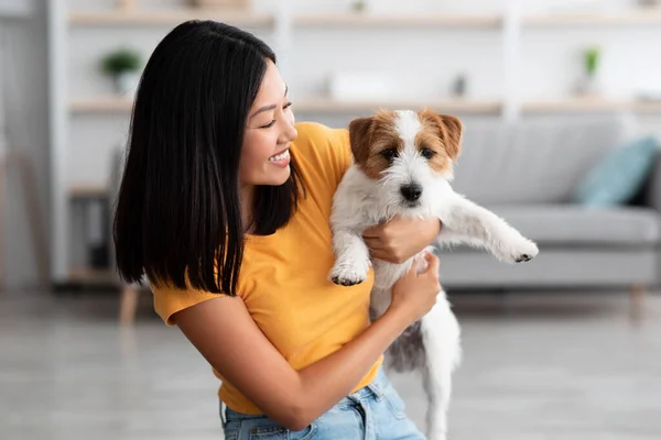 Mutlu Asyalı kadın sevimli köpeğini evde tutuyor. — Stok fotoğraf