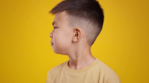 Konzept des schlechten Geruchs. Nahaufnahme Porträt kleiner asiatischer Junge, der herumschnüffelt und riecht und sich ekelhaften Geruch anfühlt — Stockvideo