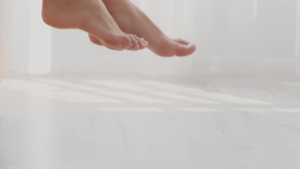 Närbild bild bild av kvinnliga fötter få ur sängen på morgonen — Stockvideo