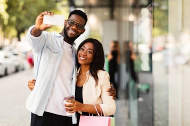 Alışveriş merkezinden sonra selfie çeken mutlu siyah çift.