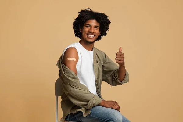 Chico negro vacunado que gesta el pulgar hacia arriba después de recibir la inyección de vacuna Covid-19 —  Fotos de Stock