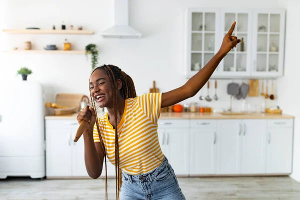 Mujer negra joven divirtiéndose mientras cocina en la cocina —  Fotos de Stock