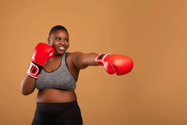 Young Black Woman Boxing Wearing Red Gloves At Studio