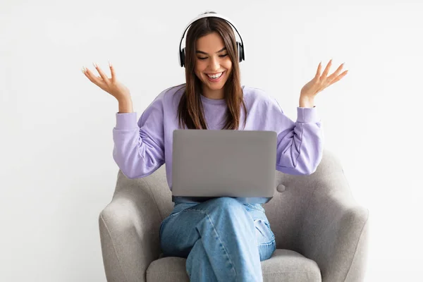 Mujer caucásica feliz teniendo llamada web en el ordenador portátil, hablando en la cámara mientras está sentado en el sillón sobre fondo blanco — Foto de Stock