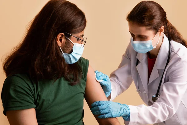 Verpleegster in het gelaat masker desinfecterende huid voor injectie — Stockfoto