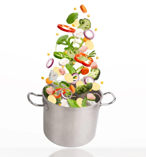 Fresh vegetables and meat flying into steel stewpot — Stock Photo, Image