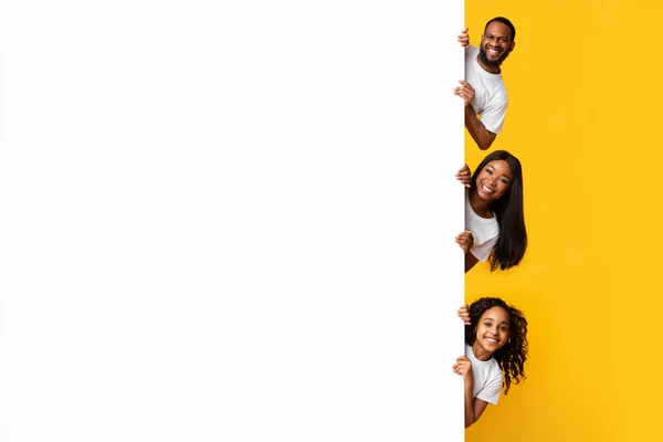 Zwarte mensen gluren uit blanco witte reclame billboard in de studio — Stockfoto