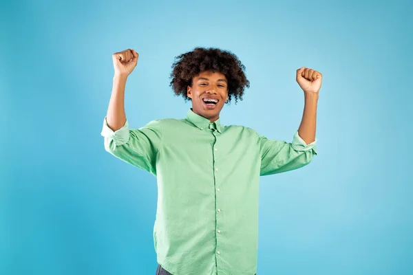 Bonne chance. heureux afro-américain adolescent guy secouant serré poings, réjouissant succès, debout sur fond bleu — Photo