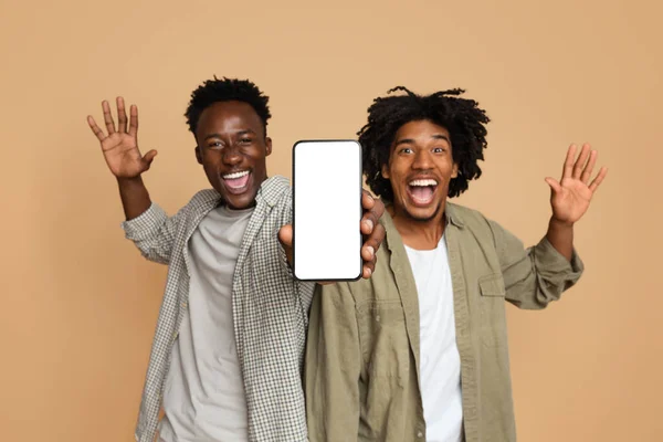 Grande App. Dois caras negros excitados demonstrando Smartphone com tela branca em branco — Fotografia de Stock