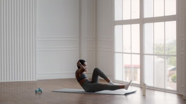 Deportiva mujer negra haciendo ejercicio de codo a rodilla abdominales crujidos, entrenamiento en casa — Vídeos de Stock