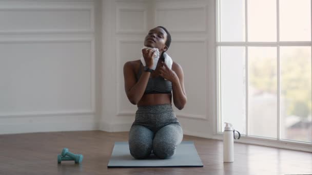 Black Sporty Lady limpiando su sudor con toalla después de un entrenamiento doméstico intensivo — Vídeos de Stock