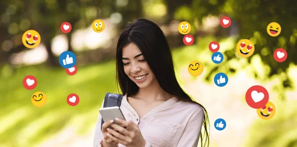 Boldog fiatal ázsiai hölgy diák chat a szociális hálózatok, blog, gépelés üzenet a parkban — Stock Fotó