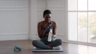 Fitness Blog 'u. Sporty Young Black Woman Smartphone 'da eğitim sırasında video kaydı yapıyor.