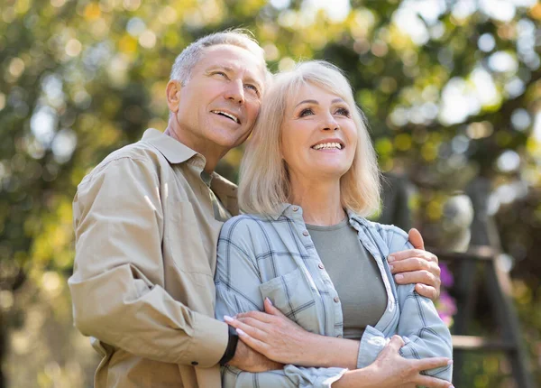 Loving senior couple enjoying warm days and peaceful nature, spouses enjoying time together outdoors — Stock Photo, Image