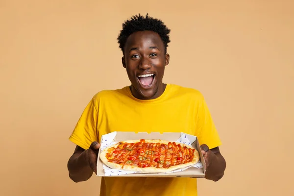 Feliz emocionado negro chico sosteniendo abierto caja con sabroso italiano pizza —  Fotos de Stock