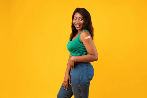 Vakcinázott fekete fiatal nő pózol stúdióban sárga háttér — Stock Fotó