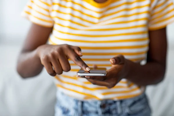 Mujer negra irreconocible usando el nuevo teléfono móvil —  Fotos de Stock