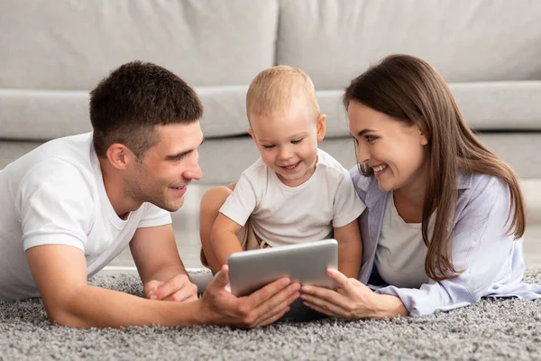 Aplicativos de desenvolvimento do bebê. Família feliz com criança infantil usando tablet digital juntos — Fotografia de Stock