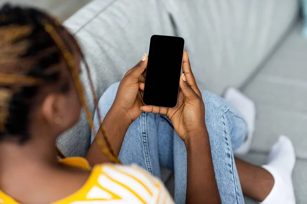 Vista superior de mujer negra usando teléfono celular con pantalla vacía —  Fotos de Stock