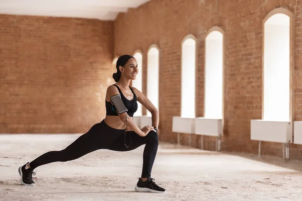 Deportiva hermosa mujer estirando los músculos de la pierna, calentando antes de entrenar al aire libre —  Fotos de Stock