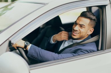 Arabada oturan gergin sürücü, trafiğe takılmış.