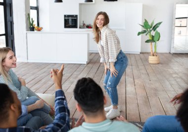 Evdeki uluslararası arkadaşlarıyla kelime tahmin oyunu oynayan neşeli beyaz bir bayan. Parti eğlenceleri