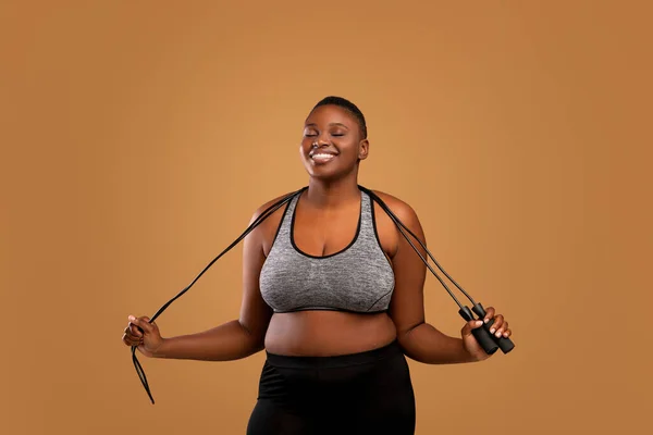 Preto gordinha mulher posando com salto corda no estúdio — Fotografia de Stock