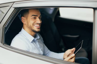 Neşeli orta doğulu işadamı havaalanına giderken e-postaları kontrol ediyor.