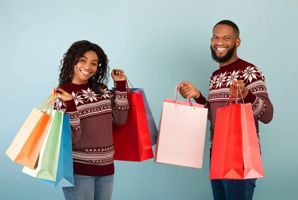 Bir sürü alışveriş, mevsimlik satış konsepti aldım. Mutlu Afro-Amerikan eşleri bir sürü renkli alışveriş torbası taşıyor. — Stok fotoğraf