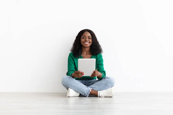 Leende svart kvinna med digital tablett, vit bakgrund — Stockfoto