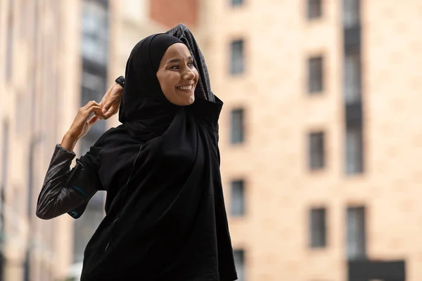 Perempuan muslim sporty dalam jilbab merentangkan otot, mempersiapkan diri untuk latihan kebugaran di luar ruangan — Stok Foto