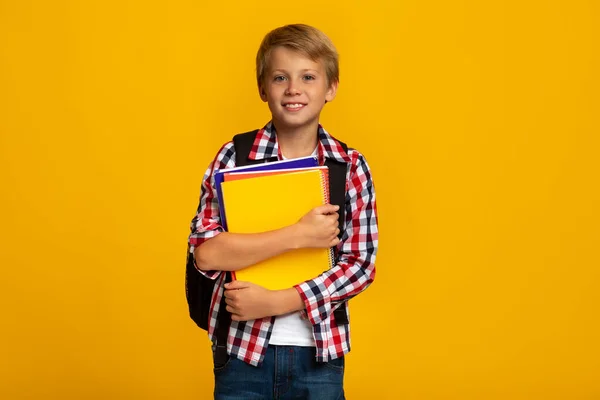 Lachende kalme Europese jonge jongen met boeken en notitieboekjes klaar om te studeren — Stockfoto