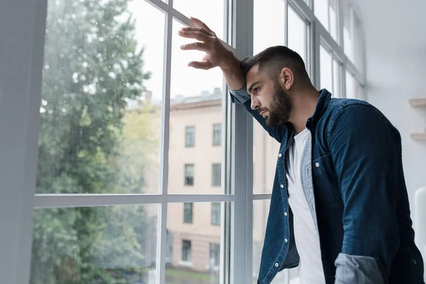 Giovane triste con preoccupato espressione faccia stressata guardando fuori dalla finestra — Foto Stock