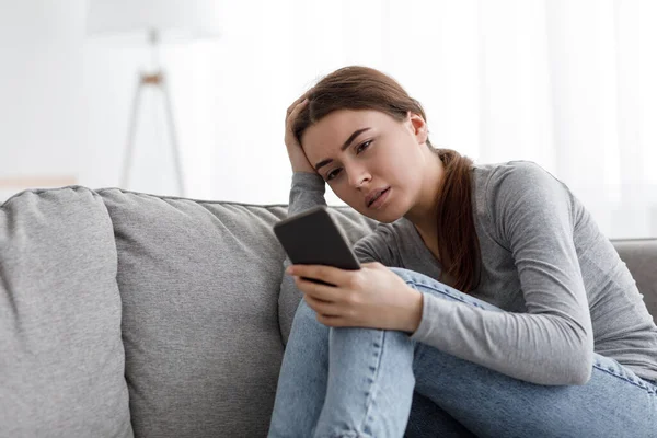 Wanhoop triest vrij boos Kaukasische duizendjarige vrouw die lijden aan depressie, huilen en lees bericht op smartphone — Stockfoto