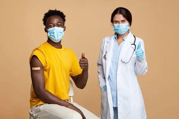 成功注射疫苗后，医生及黑人男性病人出现肿块 — 图库照片