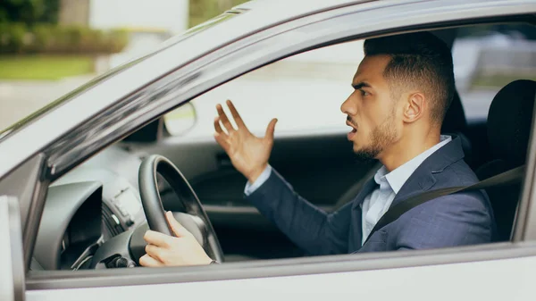 Furioso uomo d'affari mediorientale guida auto, lotta su strada, vista laterale — Foto Stock