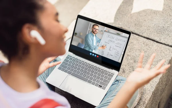 Joven dama europea en auriculares estudiando con profesor milenario en pantalla de gadget en casa — Foto de Stock