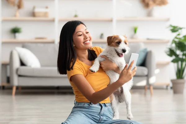 Glad asiatisk kvinna som tar selfie med sin söta hund — Stockfoto