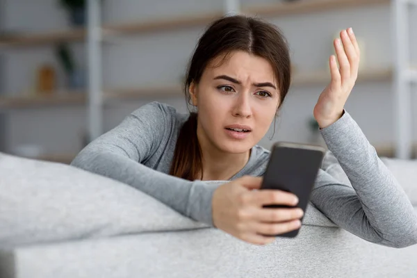 怒っている悲しいショックを受けたうつ病魅力的な若いです白人女性見ます電話とジェスチャー — ストック写真