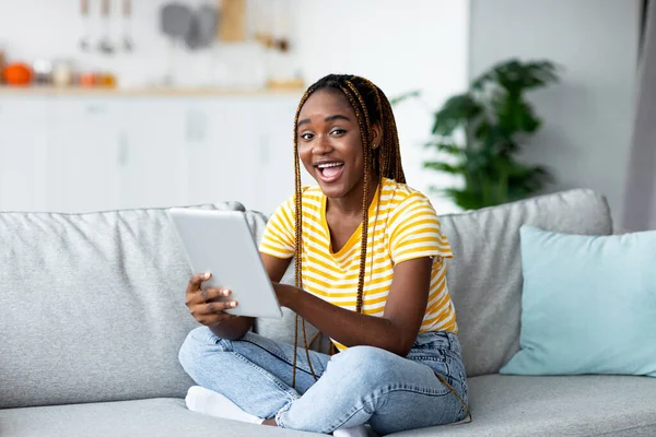 Smiling black woman trader working on pad from home