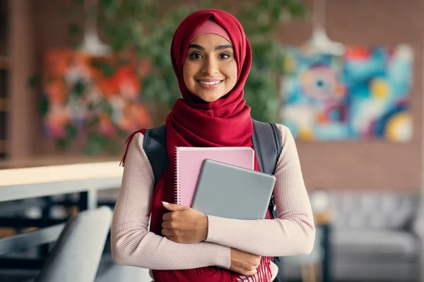 Alegre estudiante musulmana con mochila y libros en la cafetería — Foto de Stock