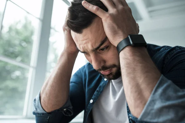 Molto sconvolto uomo infelice che soffre di mal di testa, dolore e depressione, esprime emozioni di stress — Foto Stock