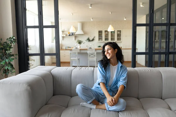 Avkopplande helgmorgon hemma. Positiv ung vit kvinna vilar på bekväm soffa inomhus, kopiera utrymme — Stockfoto