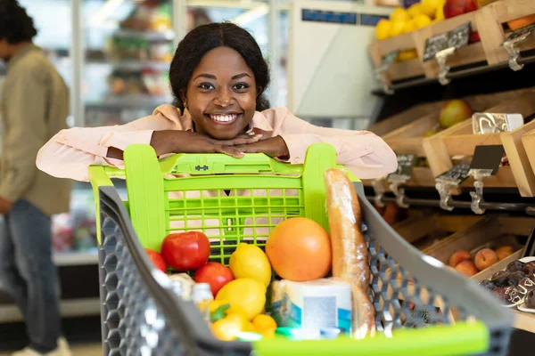 アフリカ系アメリカ人女性は、現代のスーパーマーケットでショップカートでポーズ — ストック写真